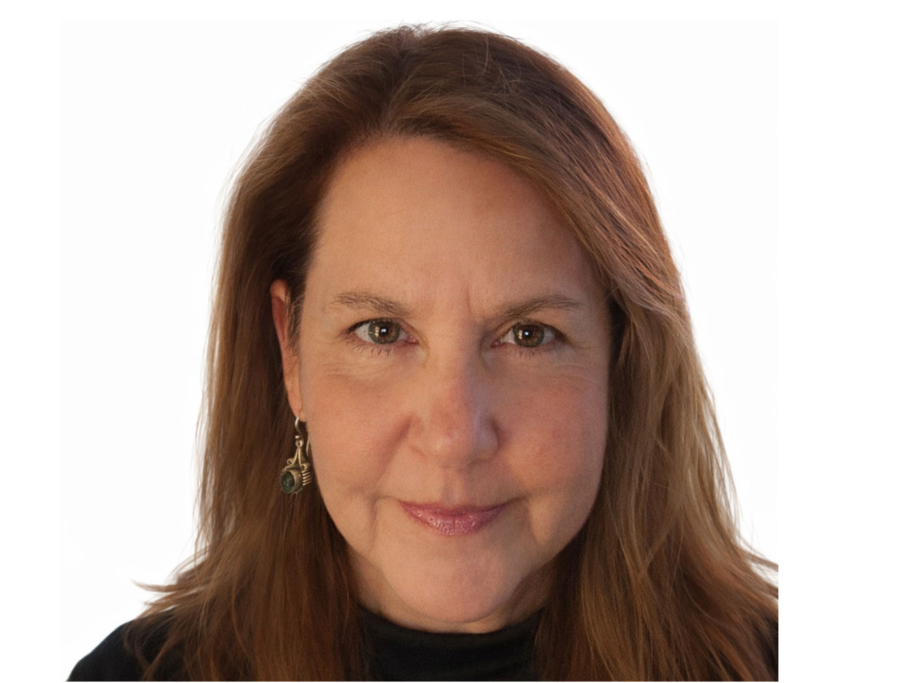Woman with light brown hair, wearing a black top and a dangling earring, smiling slightly at the camera.